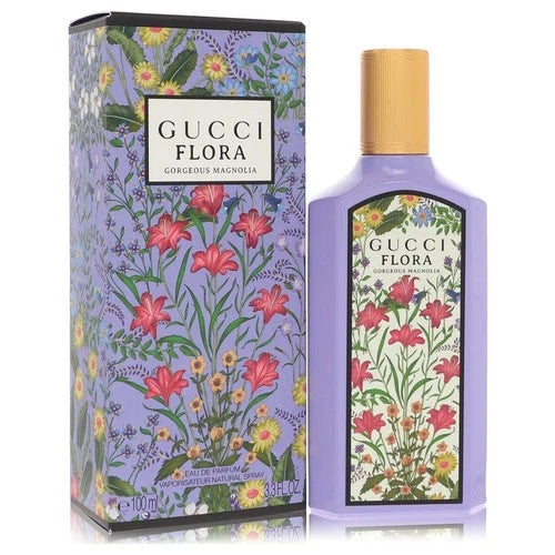 Gucci Flora Congeulé Magnolia Eau de Parfum bottle and its matching outer packaging box, both decorated with a purple floral pattern featuring red lilies and yellow wildflowers, set against a plain white background.